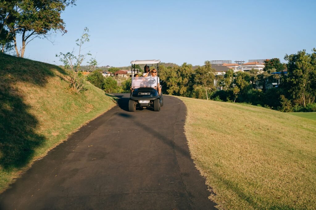 Family riding a golf cart along a paved path